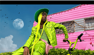 Der Bildschirm des MacBook Air zeigt das Foto einer Person in einem farbenfrohen Outfit, was die Farbpalette und die Auflösung des Liquid Retina Display veranschaulicht